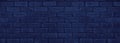 Navy blue old rough brick wall wide texture. Exterior brickwork dark backdrop. Gloomy grunge indigo color background Royalty Free Stock Photo