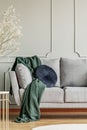 Navy blue pillow and emerald green blanket on grey sofa in elegant living room interior Royalty Free Stock Photo