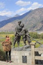 NaXi woman in front of a statue celebrating the Red Army of China in the village of ShiGu near Lijiang