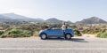 Naxos, Greece - May 2018: woman drives convertible blue car on mountain road