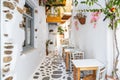 Naxos island, Cyclades Greece. Traditional outdoors cafe wooden chair table on paved street plants