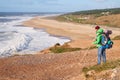 NAZARE, PORTUGAL - FEBRUARY 1, 2018: Male hiker looks at the waves from the high shore