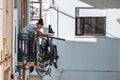 Teenage girl hangs clothing on a clothesline to dry on a balcony, typical of Portugal Royalty Free Stock Photo