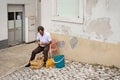 Nazare, Portugal - July 19, 2019 : A restaurant employee sits outside in the streets of Sitio peeling potatoes