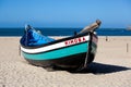 Nazare, Portugal - November 5, 2017: colorful traditional old wooden fishing boat on the beach of fishing village of Nazare . Royalty Free Stock Photo