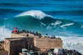 Nazare, Portugal, Surfer Riding Giant Wave in Front of Nazare Lighthouse Royalty Free Stock Photo