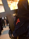 Nazarene carrying a wooden cross during the Holy Week procession in Seville, Spain