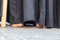 A Nazarene or penitent with black clothes is doing his penance station with bare feet in the Holy Week procession Royalty Free Stock Photo