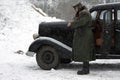 Nazi officer stands near retro car