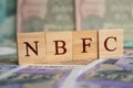 NBFC in wooden block letters on indian currency