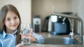 Little girl drinking from water tap or faucet in kitchen. Pouring fresh drink. Healthy lifestyle. Water quality check concept. Wor Royalty Free Stock Photo