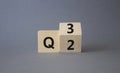 From 2nd Quarter to 3rd symbol. Turned wooden cube with words 2nd Quarter and 3rd Quarter. Beautiful grey background. Business and