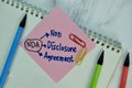 NDA - Non Disclosure Agreement write on sticky note isolated on Wooden Table Royalty Free Stock Photo