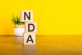 NDA - text on wood cubes stack, yellow background Royalty Free Stock Photo