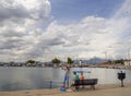 Nea Artaki, Evia island, Greece. July 2019: Fisherman with children fishing on the waterfront on a sunny afternoon on the calm Aeg