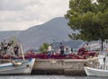 Nea Artaki, Evia island, Greece. July 2019: Fishermen mend fishing nets on the waterfront in Fishing boat on a sunny afternoon on