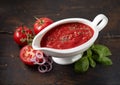 Neapolitan sauce in gravy boat between fresh tomatoes and basil