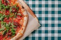 Neapolitan spicy pizza with ham, cheese, arugula, basil, tomatoes, pepperoni pepper sprayed with cheese on a wooden board on a Royalty Free Stock Photo