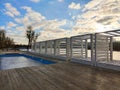 Near the beach, rows of wooden square gazebos in perspective and a small pool