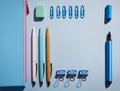 Near blue pencil case lie pens, rubber, markers, and paper clips Royalty Free Stock Photo