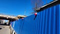 Near the bridge under repair, the fence of the construction site with a red construction lantern against the background