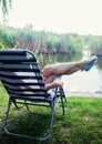 Legs of beautiful girl in blue flip flops relax at sun lounger Royalty Free Stock Photo