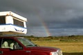 NEAR REYKJAVIK, ICELAND - JULY 28. 2008: Rainbow over hood of a Camper Royalty Free Stock Photo