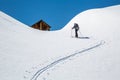 Skier skinning uphill, hiking toward a backcountry ski hut in the Rocky Mountains of British Columbia, Canada