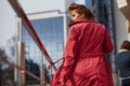 Near the silver colored railings. Adult pretty woman in warm red coat have walk in the city at her weekends time Royalty Free Stock Photo