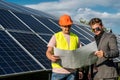 near solar panels, the employee shows the work plan to the boss