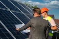 near solar panels, the employee shows the work plan to the boss