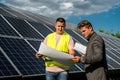 near solar panels, the employee shows the work plan to the boss