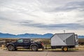 Muddy 4-Wheel Drive Pickup Truck towing utility trailer for dirt bikes parked at Rio Grande