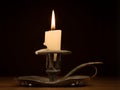 Nearly burnt down burning candle on old candle holder Royalty Free Stock Photo