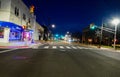 Nearly deserted city street at night without cars and only a few people Royalty Free Stock Photo