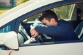 Nearly sleeping casual man keeps hand and head on the steering wheel being tired waiting in the traffic jam after work in the rush Royalty Free Stock Photo