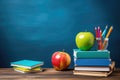 A neat arrangement of educational supplies, featuring a stack of books with an apple and pencils on top., School supplies with a