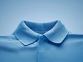 Neat collar of a blue polo shirt, emphasizing the fabric\'s texture and the garment\'s crisp, clean lines.