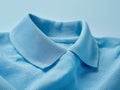 Neat collar of a blue polo shirt, emphasizing the fabric\'s texture and the garment\'s crisp, clean lines.