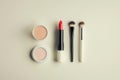 A neat display features lipstick, makeup brushes, and powders arranged on a soft, light background for a clean, stylish