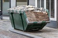 Neat industrial skip full loaded with bricks and rubble