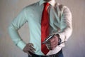 A respectable man in a business style in a white shirt with a red tie and large hands on a white background.