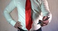 A respectable man in a business style in a white shirt with a red tie and large hands on a white background.