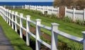 Neat sections of white picket fences with flowers and shrubs at the beach Royalty Free Stock Photo