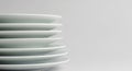 Stack of clean white plates viewed from the side with a plain background ceramic dishware Royalty Free Stock Photo