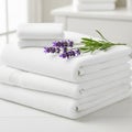 A neat stack of fluffy white towels is adorned with a sprig of fresh lavender (Lavandula), adding a Royalty Free Stock Photo