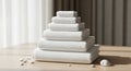 A neat stack of seven white towels of varying sizes is arranged in a pyramid shape o Royalty Free Stock Photo