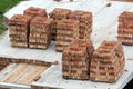 Neat stacks of red bricks lit by summer sun piled on basement floor of future house under construction. Masonry, bricklaying and h Royalty Free Stock Photo
