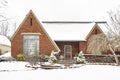 Neat and tidy brick house in fresh high contrast snow with car parked beside it - nicely landscaped