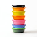 Stack of colorful plastic food containers and bowls arranged on white background Royalty Free Stock Photo